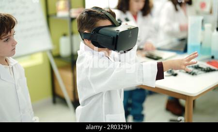 Adorable boys scientist student using virtual reality glasses at laboratory classroom Stock Photo