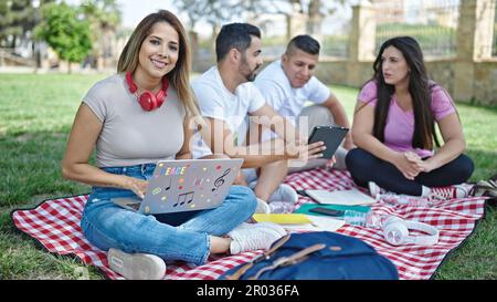 Group of people students using touchpad and laptop studying at park Stock Photo