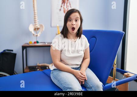 Hispanic girl with down syndrome at physiotherapy clinic covering mouth ...