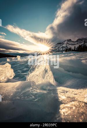 Sunset over cracked ice from frozen lake in winter season Stock Photo