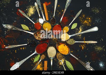 Spices and seasonings for cooking in spoons on a dark background. Stock Photo