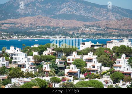 Bodrum Town houses at sunny day. Traditional white house, flowers, sailing boats, yachts in popular touristic city, Bodrum Turkey Stock Photo