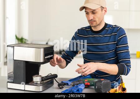 professional young worker fixing coffee machine Stock Photo