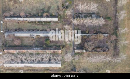 Aerial view of abandoned buildings in the field. View from above in winter. Pastel colors. Stock Photo