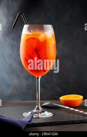 Aperol spritz cocktail and steel bar tools on slate board. Cocktail Aperol Spritz with black straw Stock Photo