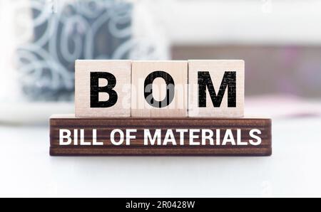 BOM bill of materials symbol. Concept words BOM bill of materials on beautiful white note. Dollar bills. Beautiful white table white background. Busin Stock Photo