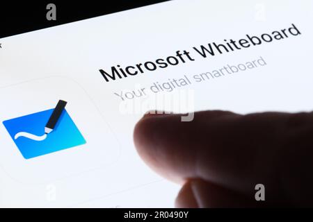 Microsoft Whiteboard app seen in App Store on the screen of ipad and blurred finger pointing at it. Selective focus. Stafford, United Kingdom, May 6, Stock Photo