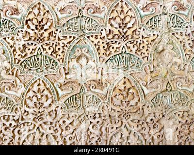 Details of stucco decoration with an Arabic writings painted in blue on the Palaces walls in Alhambra complex, Granada, Andalusia, Spain. Stock Photo