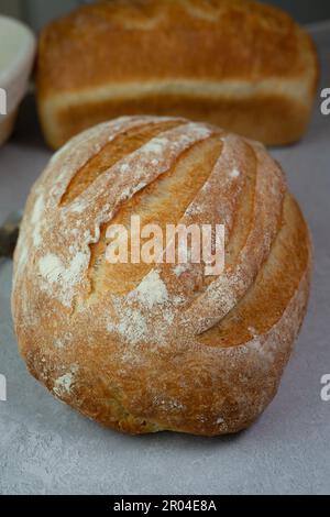 Savour the taste of freshly baked bread with this artisanal white rustic loaf. Baked to perfection, the oval-shaped loaf boasts a crispy and crusty ext. Stock Photo