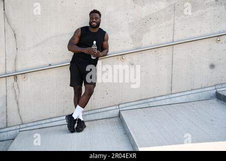 Confident fit sporty young black man standing outdoors. Stock Photo