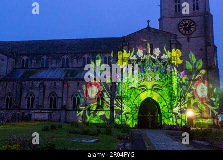 Christchurch, Dorset, UK. 6th May, 2023. Christchurch's Coronation Light Display with special images and animation celebrating the Coronation of King Charles III projected on to the front of Christchurch Priory, created by Light Art Creatives in collaboration with Event Temps UK. Crowds flock to the Priory on a misty murky evening to see reminders of this historic event - the first time Christchurch Priory has hosted a projected light display. Credit: Carolyn Jenkins/Alamy Live News Stock Photo