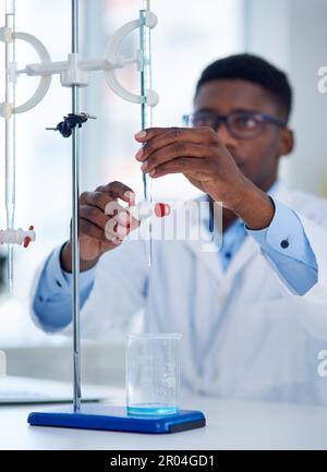 Everything seems to be in place. a focused young male scientist adjusting a piece of scientific equipment before conducting experiments inside of a Stock Photo