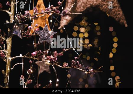 Festive winter tree decorations with large silky poinsettia flowers,  glitter tree balls and golden mesh ribbons, seasonal Christmas ornamentas  Stock Photo - Alamy