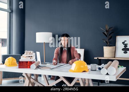 Youll always have plenty on your table in this profession. an attractive female architect working on building plans and designs in her office. Stock Photo