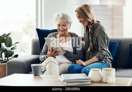So how do I search for my friends. a senior woman and her daughter using a digital tablet together. Stock Photo
