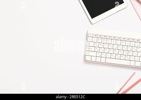 Composition with keyboard, pens and tablet computer on white background Stock Photo