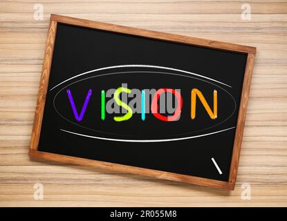 Small chalkboard with word Vision on wooden background, top view Stock Photo