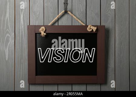 Small chalkboard with word Vision hanging on grey wooden wall Stock Photo
