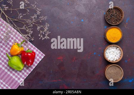 top view colored bell-peppers with different seasonings on grey background vegetable pepper spicy hot food Stock Photo