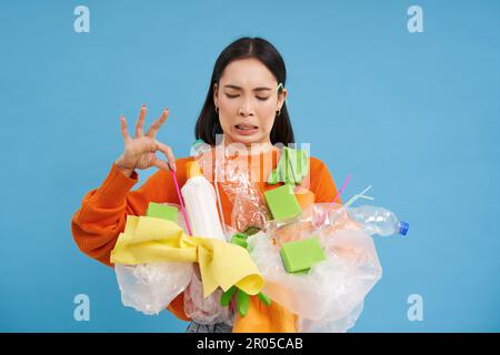 Disgusted asian woman, holds stinky garbage, recycling her waste with ...