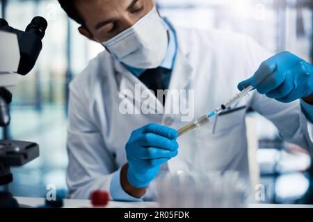 I have to put just enough. a young male scientist working in a lab. Stock Photo