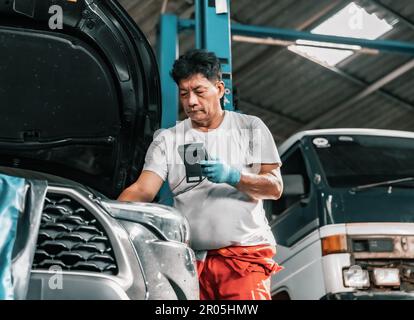 Experienced auto mechanics inspect car battery terminals and voltage to