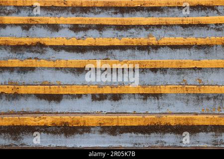 Close up retro image of weathered blue stairs with yellow stripes. Stock Photo
