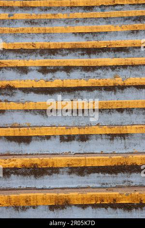 Close up retro image of weathered blue stairs with yellow stripes. Stock Photo