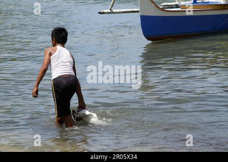 Fishermen on Batuwingkung Island, North Sulawesi, Indonesia are slicing shark fins and shark meat that they have just caught. Stock Photo