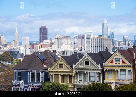 Old victorian houses in San Francisco with the downtown skyline in the back Stock Photo
