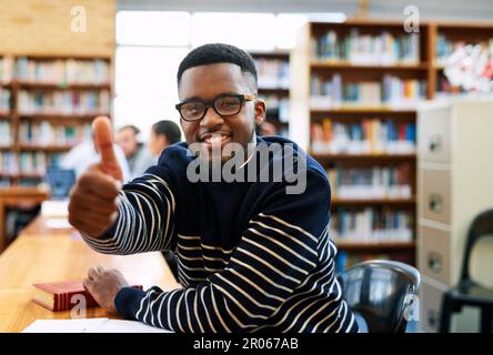Im positive about my future. Cropped portrait of a student showing thumbs up while sitting in the library. Stock Photo