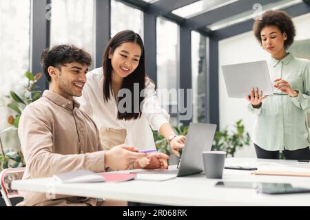 Diverse Business Team Of Three Working Together On Laptop Indoor Stock Photo