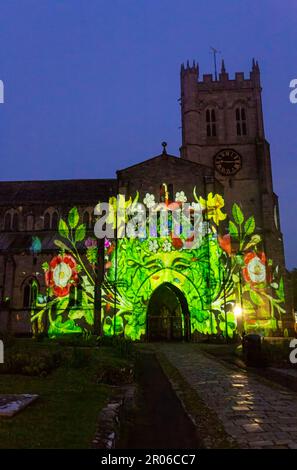 Christchurch, Dorset, UK. 6th May, 2023. Christchurch's Coronation Light Display with special images and animation celebrating the Coronation of King Charles III projected on to the front of Christchurch Priory, created by Light Art Creatives in collaboration with Event Temps UK. Crowds flock to the Priory on a misty murky evening to see reminders of this historic event - the first time Christchurch Priory has hosted a projected light display. Credit: Carolyn Jenkins/Alamy Live News Stock Photo