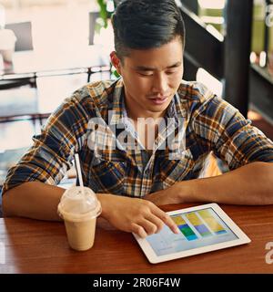 Tracking all his progress online. a young designer using a digital tablet in an office. Stock Photo