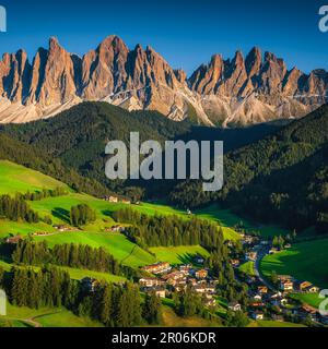 Great view from the hill with green fields and beautiful mountains. Fantastic valley with alpine village and pastures on the slopes, Santa Maddalena v Stock Photo