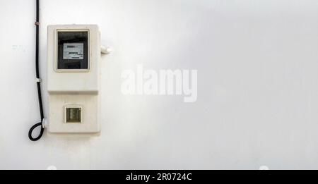 Old outdoors electricity meter device on empty whitewashed wall background, Cyclades island, Greece. Measurement of kilowatt hour. Copy space Stock Photo
