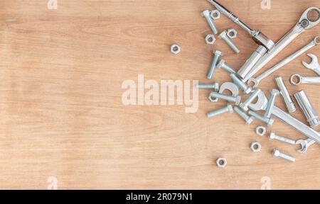 Spanners and sockets with nuts and bolts on a wooden background. Stock Photo