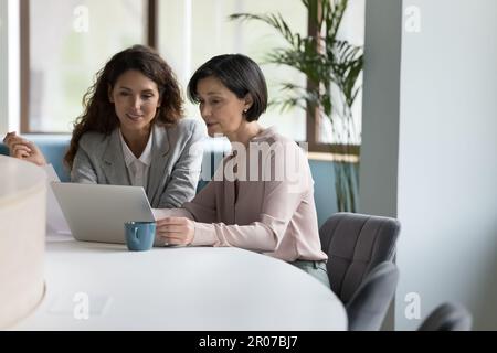 Two women colleagues working together use computer Stock Photo