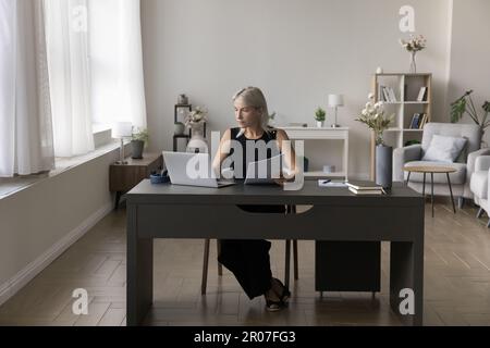 Confident mature business lady working from home Stock Photo
