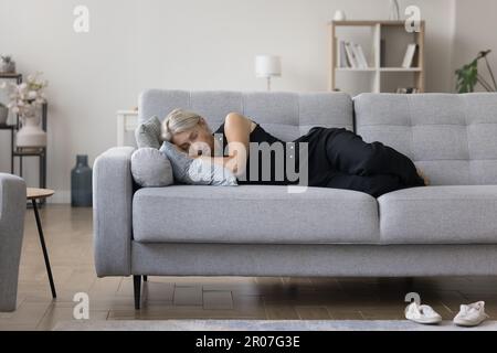 Calm homeowner woman lying on side on comfortable sofa Stock Photo