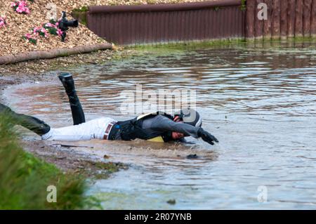 Bristol, UK. 07th May, 2023. 7th May 2023. Tom Crisp pretending to swim after falleing from his horse at the Lake complex during the Cross Country Phase on Day 3 of the 2023 Badminton Horse Trials presented by MARS at Badminton House near Bristol, Gloucestershire, England, United Kingdom. Credit: Jonathan Clarke/Alamy Live News Stock Photo