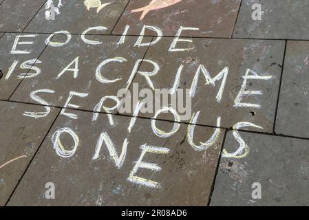 Chalked graffiti by Extinction Rebellion at encampment around Parliament Square in front of the Houses of Parliament, London, UK. Eocide spelling Stock Photo