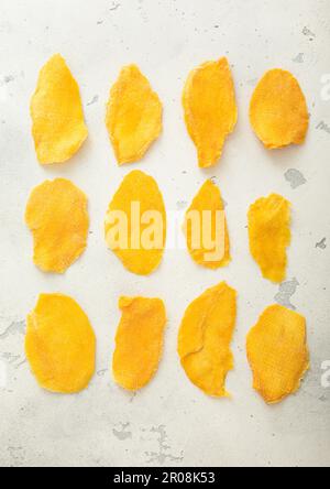Slices of large sweet dried mangoes on light background. Stock Photo