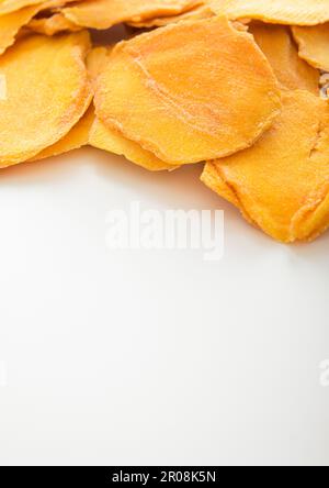 Dried large sweet mango slices on white background. Stock Photo