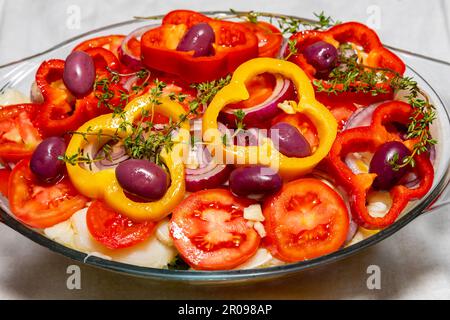 Traditional Portuguese bacalhoada with potatoes, onions and olive oil, garnished with fresh herbs Stock Photo