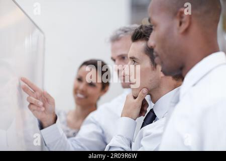 Focused on the task at hand. A group of professionals strategize together. Stock Photo
