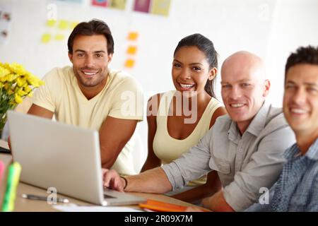 No I in team. Portrait of a diverse group of designers discussing a project over a laptop. Stock Photo