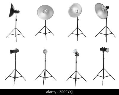 Set with studio flash lights with reflectors on tripods against white background Stock Photo