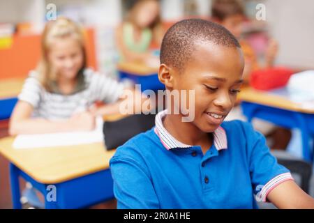 We all want the best for our kids - Education Funds. Young african-american boy concentrating on his work in class - copyspace. Stock Photo
