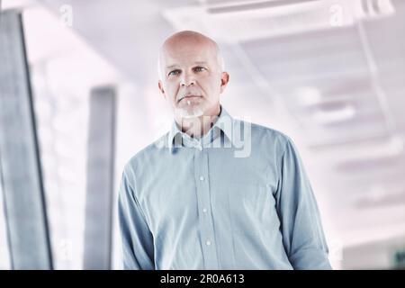 dynamic image of an elderly man absorbed in his own thoughts walking in a modern or technological environment, confident in the future and in humanity Stock Photo
